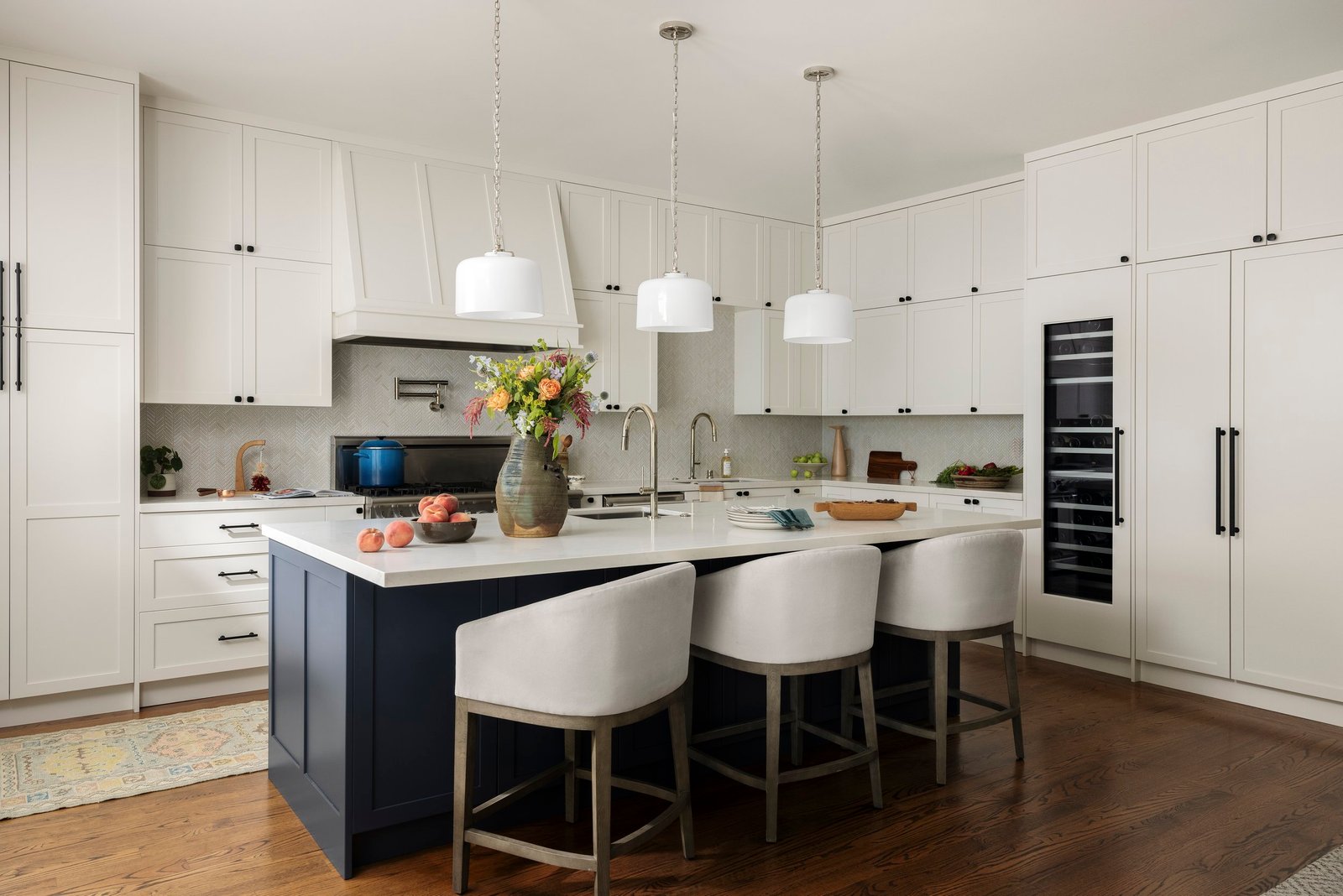 Modern kitchen with island, white cabinet and blue island combination with white counter top.